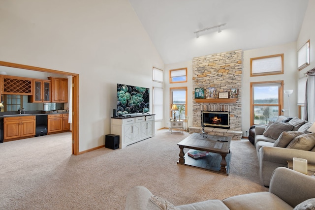 living area featuring indoor wet bar, light carpet, high vaulted ceiling, and a fireplace