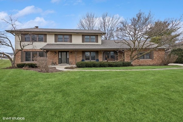 traditional home featuring brick siding and a front lawn