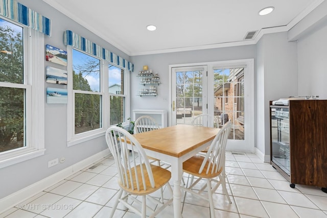 dining room featuring crown molding, light tile patterned floors, visible vents, and baseboards