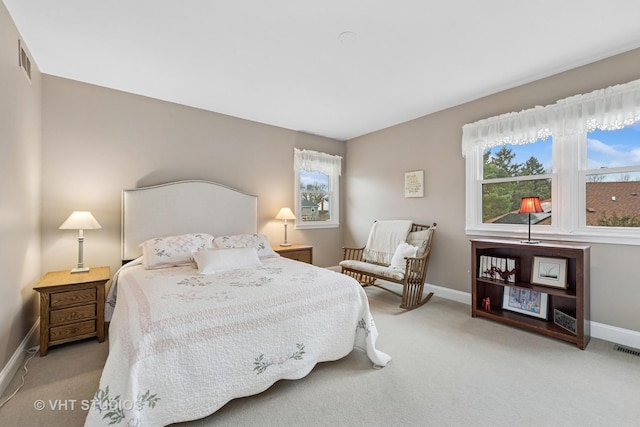 carpeted bedroom featuring visible vents, multiple windows, and baseboards