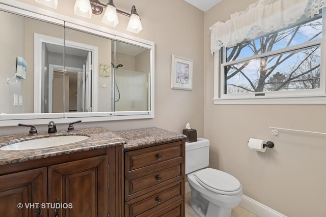 bathroom featuring baseboards, toilet, and vanity