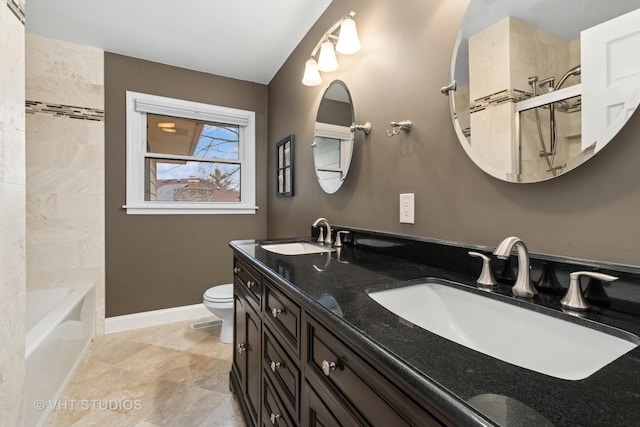 full bath featuring a sink, baseboards, toilet, and double vanity