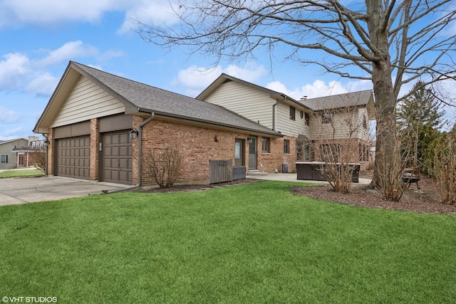 view of home's exterior with a lawn, concrete driveway, a garage, brick siding, and a hot tub