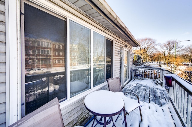 snow covered deck featuring a balcony