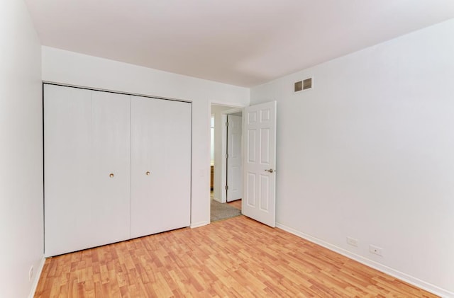 unfurnished bedroom featuring light hardwood / wood-style floors and a closet