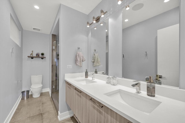 full bathroom featuring double vanity, a sink, toilet, and baseboards