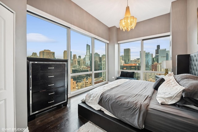 bedroom with dark hardwood / wood-style flooring and an inviting chandelier