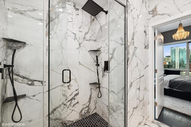 bathroom featuring a shower with shower door and a chandelier