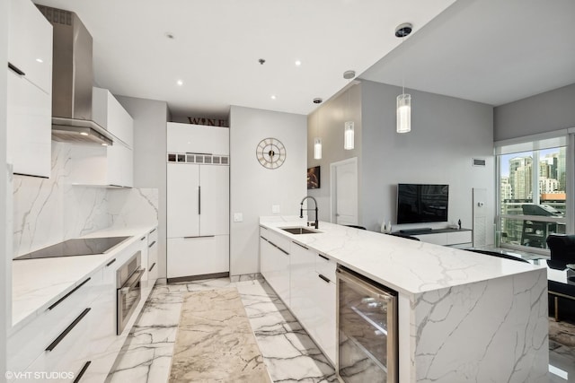 kitchen featuring wall chimney range hood, hanging light fixtures, black electric stovetop, paneled built in fridge, and beverage cooler