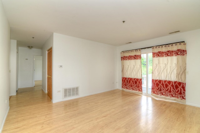 unfurnished room with light wood-style floors, baseboards, and visible vents