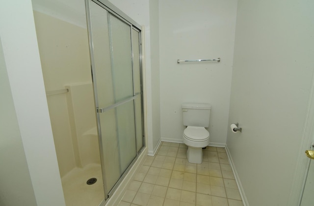 bathroom featuring a stall shower, tile patterned flooring, toilet, and baseboards