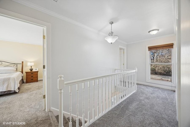 corridor featuring carpet floors, ornamental molding, and an upstairs landing