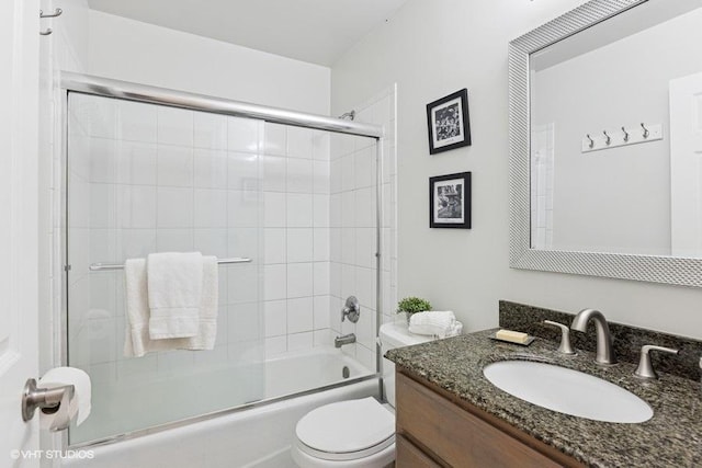 full bathroom featuring bath / shower combo with glass door, vanity, and toilet