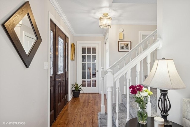 foyer with stairway, crown molding, and wood finished floors