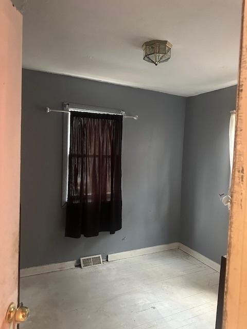 spare room featuring visible vents and baseboards