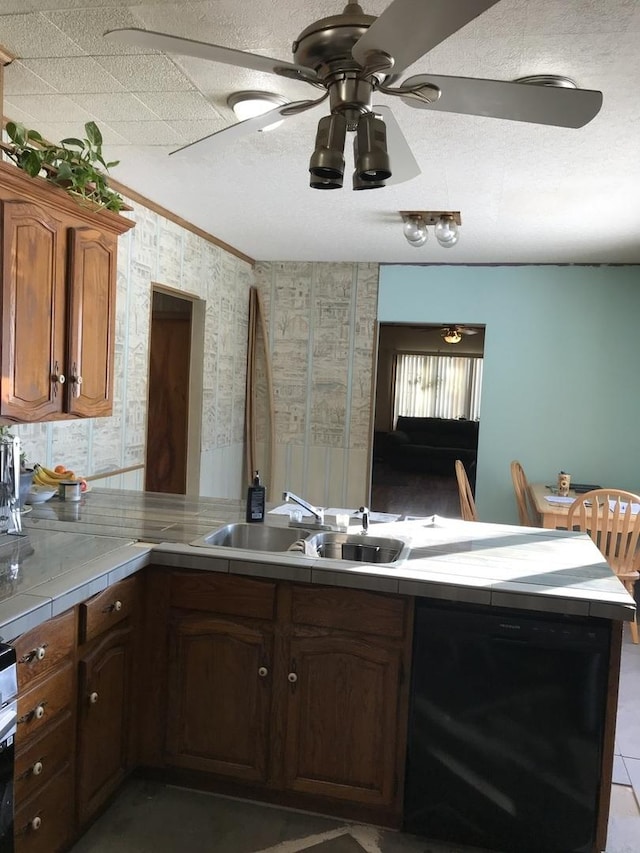 kitchen with sink, tile countertops, black dishwasher, kitchen peninsula, and ceiling fan