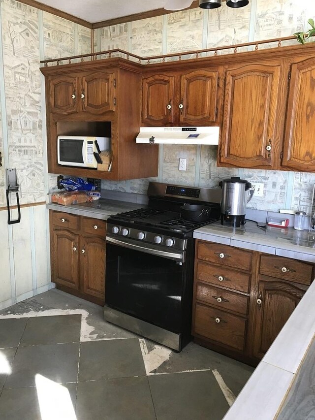 kitchen with tile countertops and gas stove