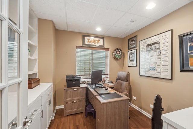 office with a paneled ceiling, dark wood finished floors, visible vents, and baseboards