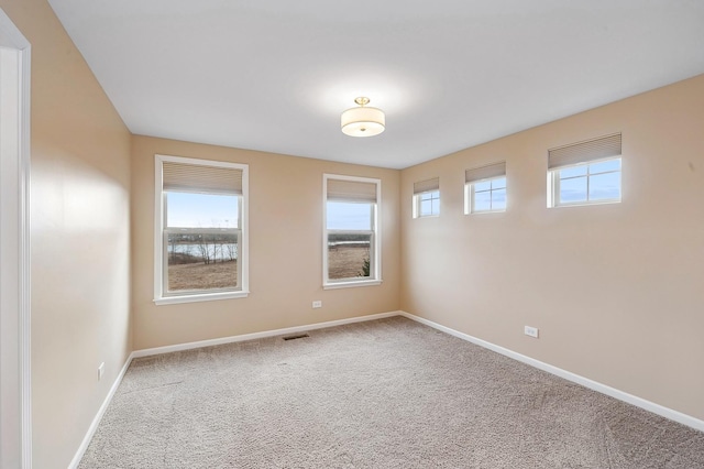 empty room featuring baseboards and carpet flooring