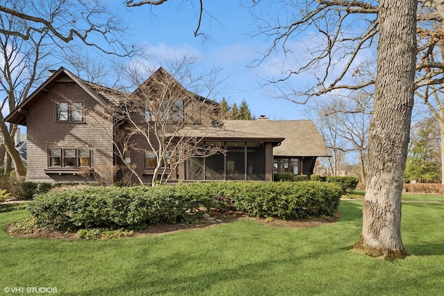 back of house with a yard, a sunroom, and a chimney