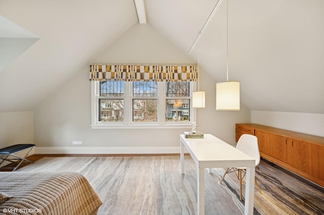 bedroom with lofted ceiling with beams, wood finished floors, and baseboards