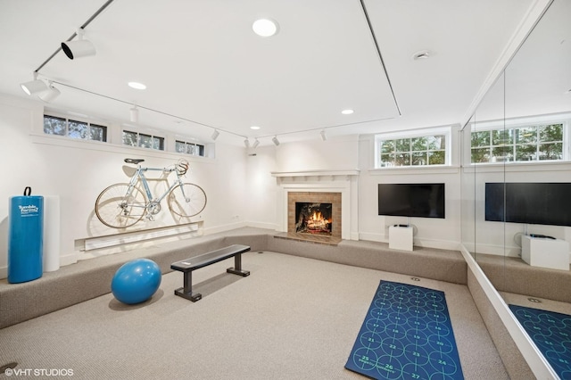 exercise room with recessed lighting, carpet, a brick fireplace, and track lighting