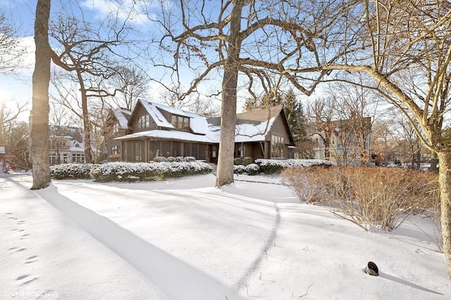 view of snowy exterior featuring a sunroom