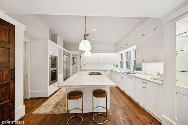 kitchen featuring white cabinets, stainless steel appliances, dark wood-type flooring, and a sink