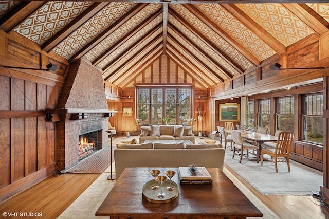 living room with wooden walls, a brick fireplace, a baseboard heating unit, wood finished floors, and high vaulted ceiling