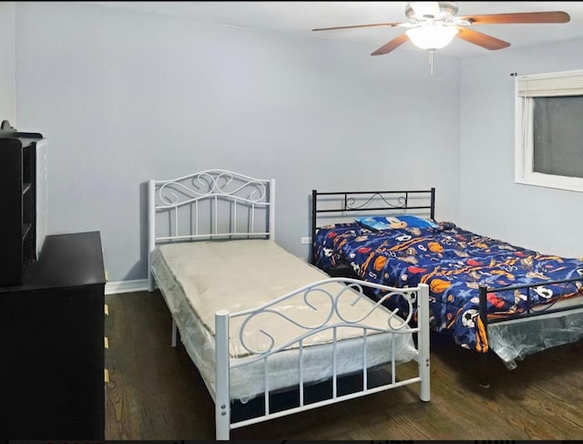 bedroom with dark hardwood / wood-style floors and ceiling fan