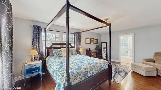 bedroom with wood-type flooring and ensuite bath