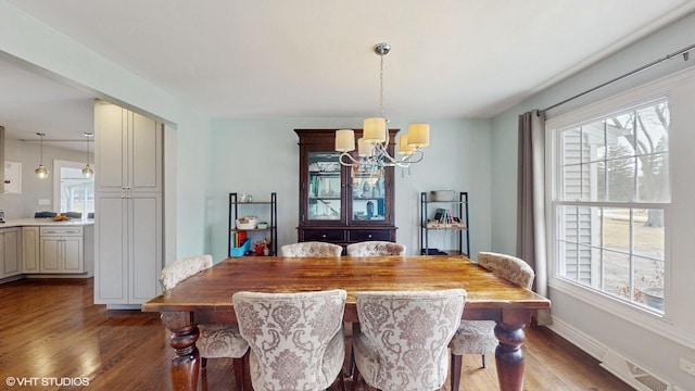 dining area with wood-type flooring and a chandelier