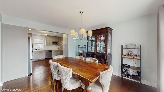 dining room with dark hardwood / wood-style flooring and a notable chandelier