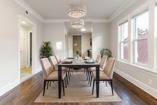 dining room with dark hardwood / wood-style flooring, a chandelier, and crown molding