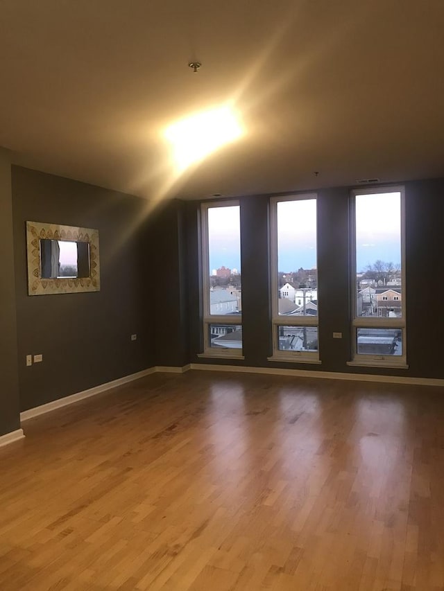 unfurnished room featuring wood-type flooring and vaulted ceiling