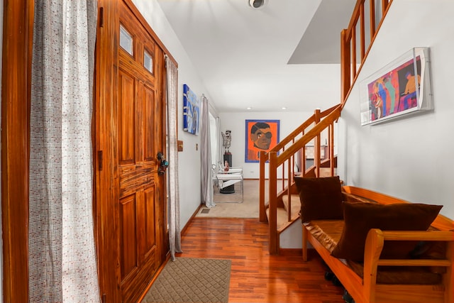 entrance foyer featuring stairs, baseboards, and wood finished floors