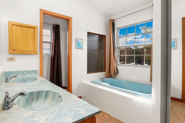 full bath with double vanity, a garden tub, and a sink