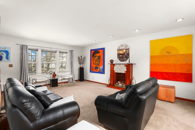 living area featuring carpet floors, a tile fireplace, and baseboards