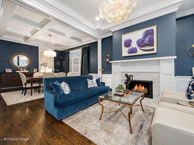 living room with beam ceiling, dark hardwood / wood-style floors, coffered ceiling, a notable chandelier, and a fireplace