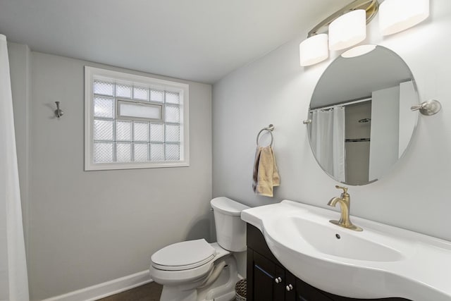 bathroom featuring a shower with shower curtain, vanity, toilet, and baseboards