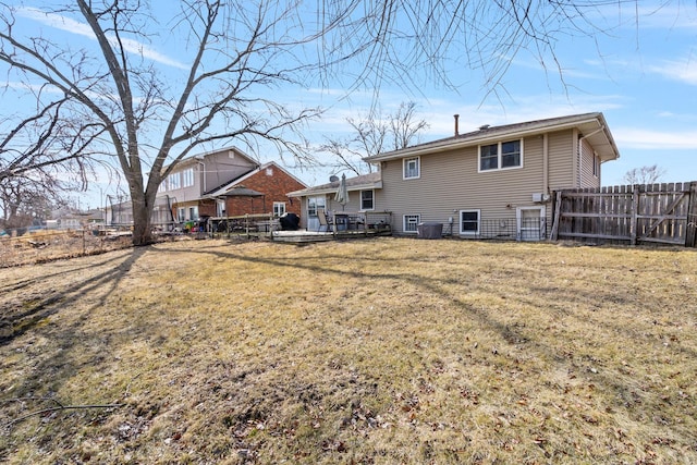 back of house with central AC unit, a lawn, fence, and a wooden deck