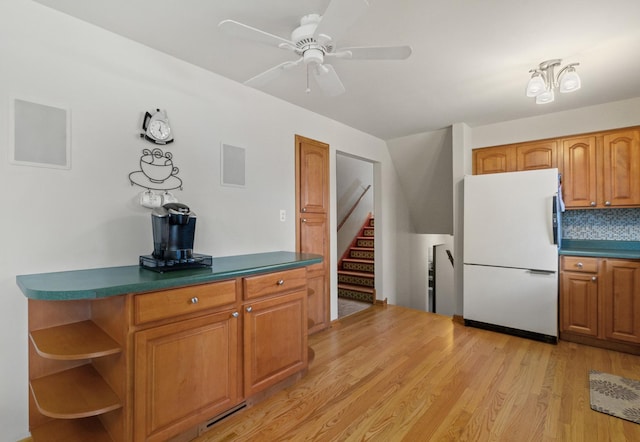 kitchen with open shelves, light wood-style flooring, brown cabinetry, freestanding refrigerator, and ceiling fan