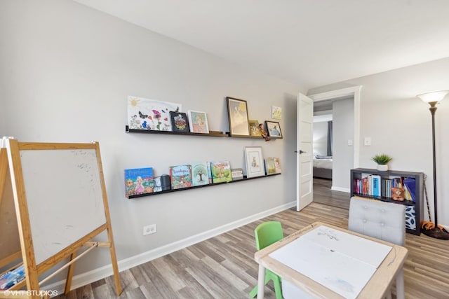 rec room with baseboards and wood finished floors