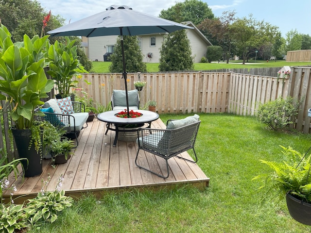 view of yard with an outdoor fire pit, a fenced backyard, and a deck