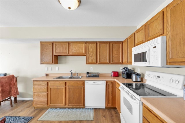 kitchen featuring sink, white appliances, and light hardwood / wood-style floors