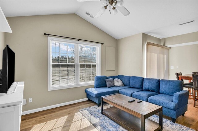 living room with ceiling fan, vaulted ceiling, and light hardwood / wood-style flooring