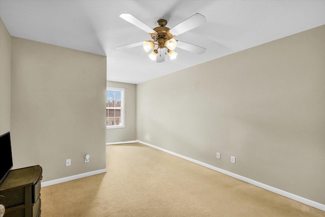 carpeted spare room featuring ceiling fan