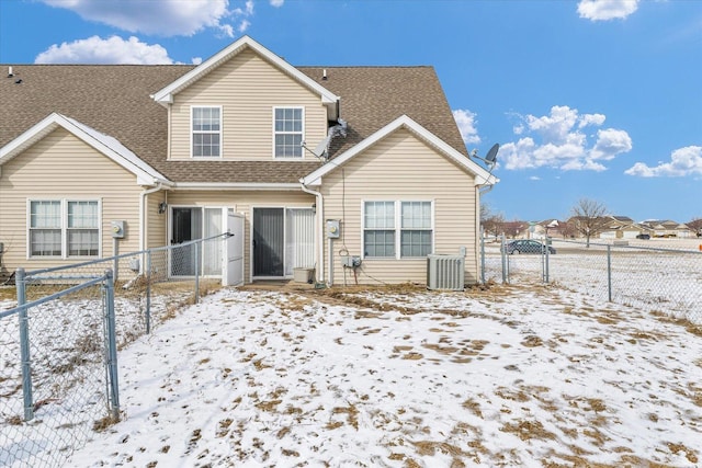 snow covered back of property featuring central AC