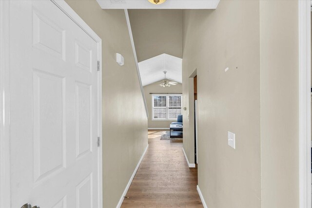 hall with hardwood / wood-style flooring and vaulted ceiling