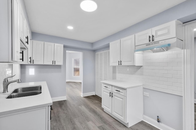 kitchen with sink, white cabinets, and light hardwood / wood-style floors